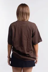 Remera marrón de corte holgado con estampado de elipse y estrella en color rojo.