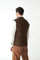 Chaleco de punto color beige con diseño de trenzas, escote en V y sisas amplias.