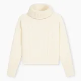 Sweater tejido color crudo, con cuello alto y diseño de trenzas verticales en el frente.