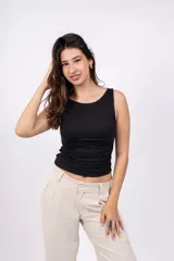 Musculosa blanca ajustada al cuerpo, con cuello redondo y sisas amplias.