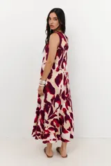 Vestido midi sin mangas, con cuello redondo, estampado animal print en tonos rojo, bordó y beige. Presenta cortes diagonales en el cuerpo que añaden estructura al diseño.
