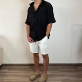 Bermuda negra de lino con corte arriba de la rodilla y cordón ajustable en la cintura.