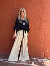 Estola negra con lazo, confeccionada en viscosa y fibrana. Accesorio fluido y confortable para usar atado o no, ideal para realzar cualquier look.