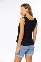 Musculosa celeste de algodón y poliéster, con breteles anchos con volados y tres botones en el escote.