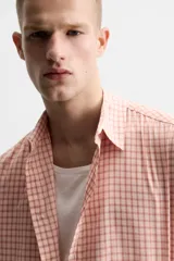 Camisa de manga larga con estampado a cuadros en tonos rosa y blanco.