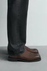 Botín marrón de piel con acabado serraje, cierre de cremallera lateral, plantilla de piel, horma cuadrada y suela a contraste con ligero tacón.