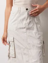 Falda larga color beige, de corte recto, con bolsillos cargo laterales y traseros.