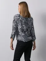 Blusa estampada con escote en V y abertura con botones. Largo de manga regulable con presilla y botón. Terminación de ruedo con nudo.