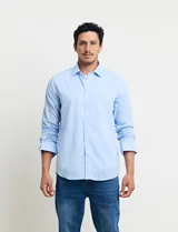Camisa celeste de manga larga con cuello button-down, confeccionada en tejido rústico de algodón y lino.