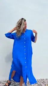 Vestido camisero midi azul eléctrico de lino, con cuello camisero, mangas cortas y cierre frontal con botones blancos.
