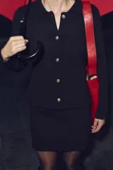 Chaqueta tipo blazer de punto color negro, con cuello solapa, manga larga, falsos bolsillos delanteros con tapetas y cierre frontal con botones dorados.