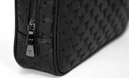 Bolso tipo neceser unisex, color negro con estampado de logos de la marca.