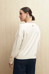 Sweater de punto fino color verde oliva, con calado delicado en hombros y mangas, cuello redondo y mangas largas.