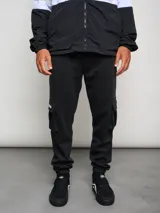 Pantalón de jogging gris con bolsillos cargo laterales y logo de la marca bordado en la pierna.