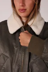 Campera bomber verde militar con cuello de corderito desmontable y cierre frontal.