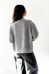Buzo gris con efecto lavado, cuello redondo y calce oversize.