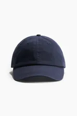 Gorra azul marino de sarga de algodón con ojales bordados, trabilla ajustable y cierre de metal atrás.