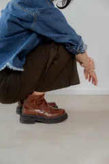 Botas cortas de cuero color hueso, con puntera redondeada, ajuste con doble tira con velcro color verde oliva y suela track color negro.