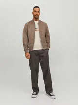 Campera bomber color marrón claro de cuero sintético, con cuello tipo baseball, cierre frontal con cremallera, bolsillos laterales con cremallera y bolsillo en la manga.
