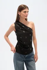 Top negro asimétrico con un solo bretel ancho, bordado con cuentas y cierre lateral.