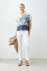Camisa de manga corta con estampado paisley en tonos azul y blanco, con cuello clásico y cierre con botones.