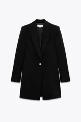 Blazer negro largo con cuello solapa, manga larga con hombreras, bolsillos delanteros de vivo y cierre frontal con un botón.