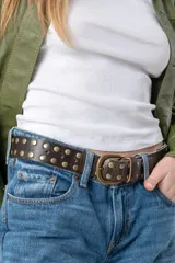 Cinturón bordeaux de cuero vacuno con tachas plateadas.