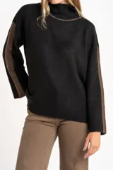 Sweater negro de tejido grueso con cuello alto acanalado. Presenta una franja decorativa en las mangas y el cuello en hilo marrón con brillo (lurex).