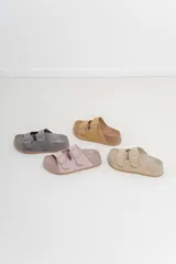 Sandalias color rosa con doble hebilla ajustable y suela marrón.