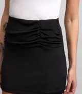 Minifalda negra con efecto cruzado y fruncido lateral.