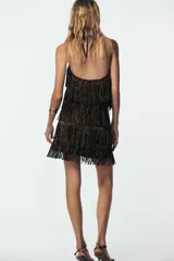 Top marrón con flecos y abalorios, escote halter y espalda descubierta.