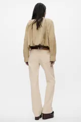 Pantalón de tiro alto color beige, con bolsillos laterales y corte ancho.
