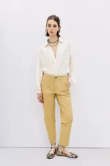 Pantalón de cuero ovino color dorado, de corte recto y largo al tobillo.