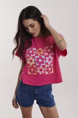 Remera gris de algodón con estampado colorido de flores en formato cuadrado.