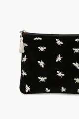Sobre negro de terciopelo con cierre de cremallera y borla decorativa. Estampado con abejas bordadas en color plateado.