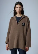 Sweater marrón de punto con cuello polo, cierre de cremallera parcial y parche bordado en el pecho.