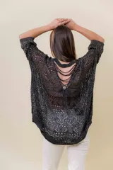 Buzo tejido liviano color bronce/marrón con diseño calado y textura sutilmente brillante. Presenta un calce amplio y mangas amplias, con detalle de tiras entrecruzadas en la espalda.