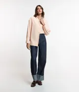Camisa color rosa pálido, de corte amplio y alargado, confeccionada en viscosa. Tiene cuello camisero, abotonadura frontal y mangas largas con puños abotonados.