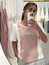 Remera blanca con panel central celeste, cuello redondo y mangas cortas. Presenta detalles de puntilla en el panel lateral.