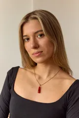 Collar dorado con cadena fina y dije colgante en forma de lágrima de piedra natural azul con vetas blancas.