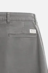 Pantalón chino azul marino, corte skinny fit, confeccionado en tejido de algodón con elasticidad. Cuenta con bolsillos frontales y traseros de vivo. Cierre frontal con cremallera y botón.
