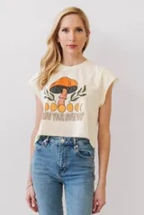 Camiseta crop color crema con mangas cortas y cuello redondo. Estampado frontal con un hongo y la frase "Grow Your Own Way".