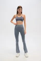 Calza gris de corte ajustado y tiro alto, con textura acanalada y terminación acampanada.