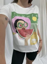 Remera blanca de algodón con estampado de una mujer comiendo sandía y texto 'Summer'.
