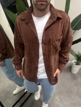 Sobrecamisa marrón de pana con cuello clásico, cierre abotonado y bolsillo de parche en el pecho.