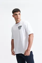 Remera blanca de algodón, corte oversize, manga corta y cuello redondo.