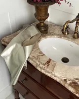Chaleco marrón de gamuza con corte clásico y costuras decorativas.
