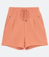 Short de poliéster color salmón con cintura elástica, cordón de ajuste, bolsillos laterales y pliegues frontales.