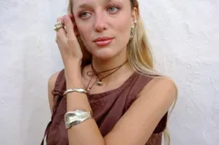 Brazalete rígido plateado con textura irregular.