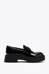 Zapato tipo mocasín negro acharolado con antifaz y suela track.